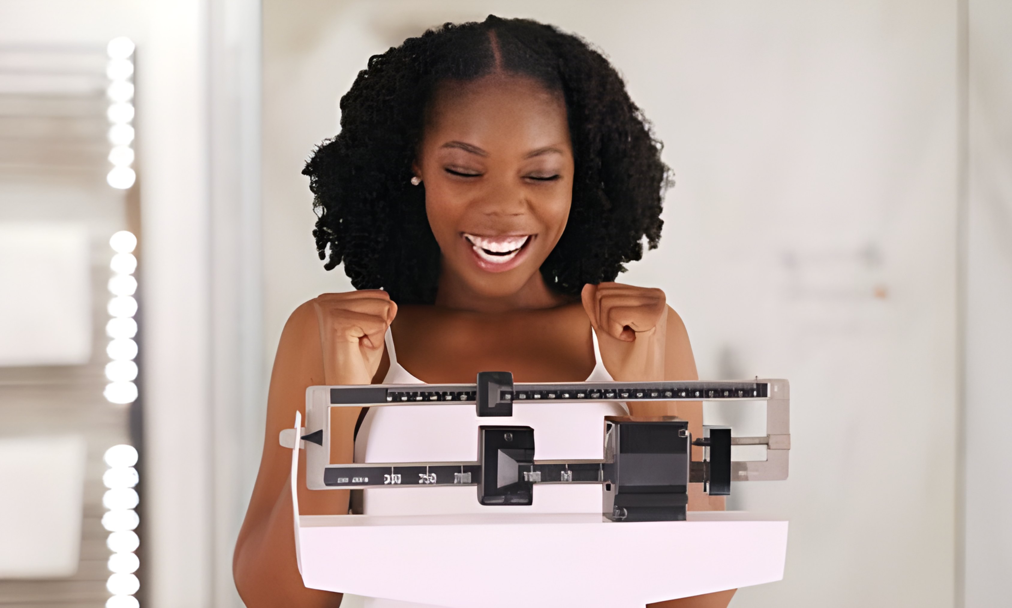 Woman celebrating weight loss success on scale